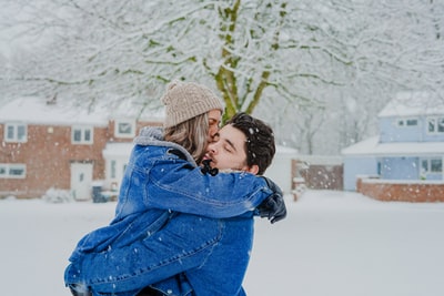 在雪地上拥抱的男人和女人